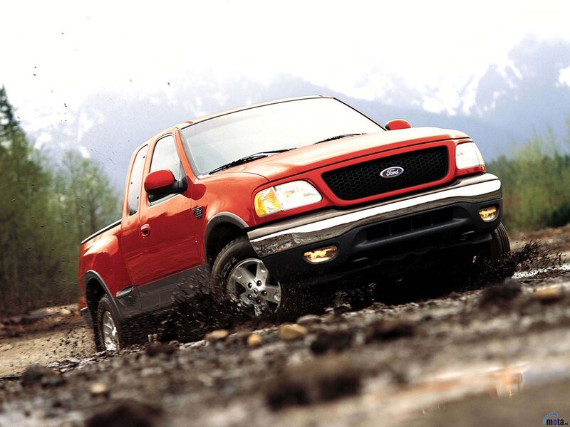 Red Ford F-150 driving through mud