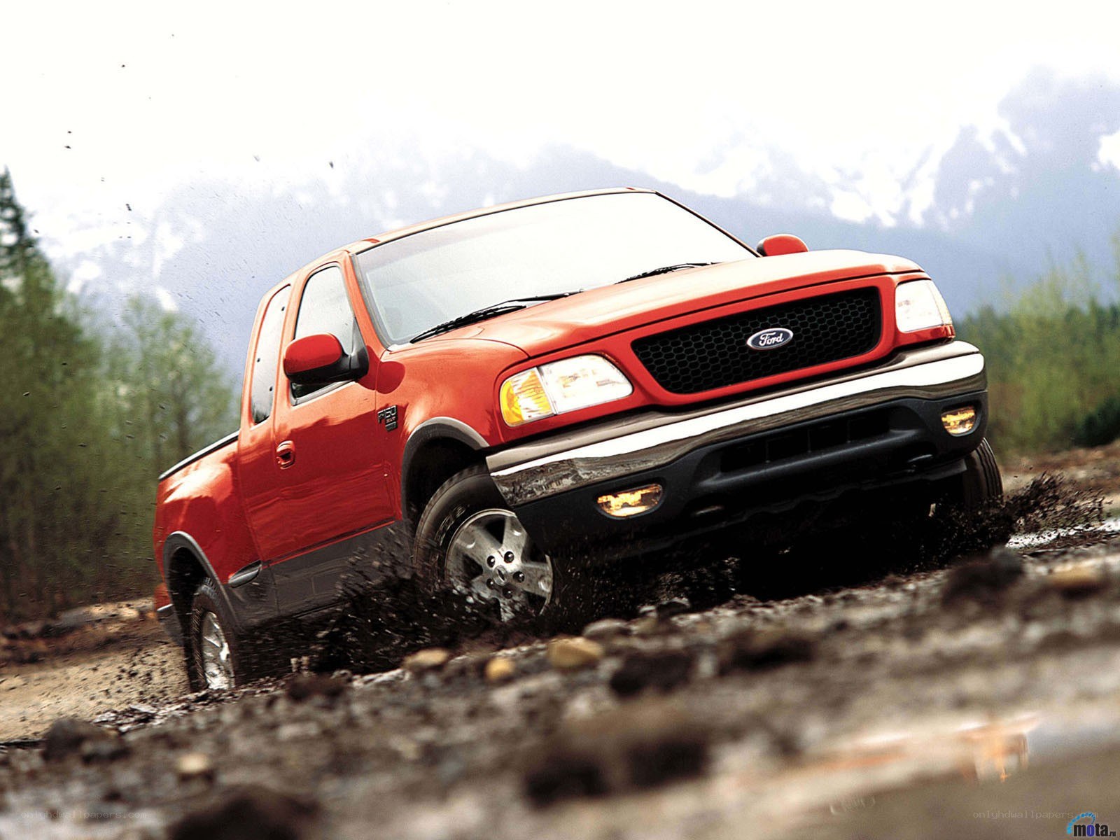 Red Ford F-150 driving through mud