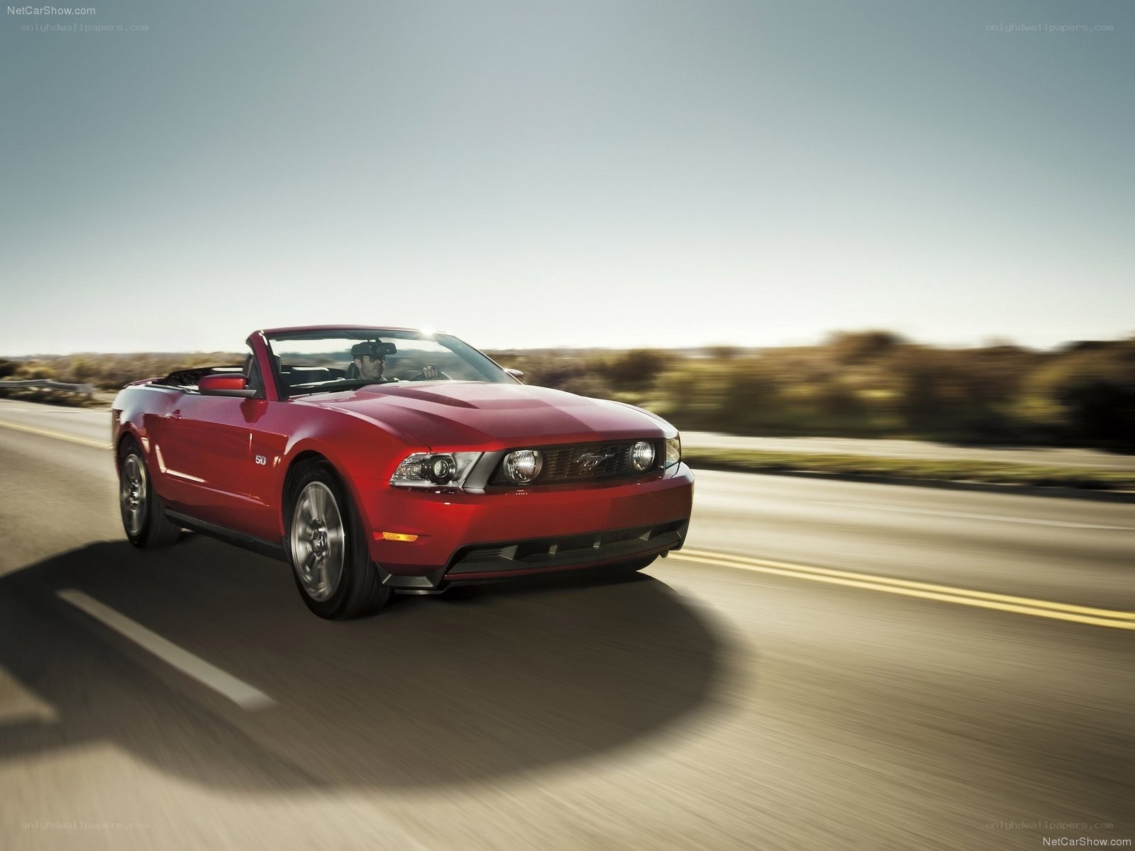 Red Ford Mustang convertible in motion