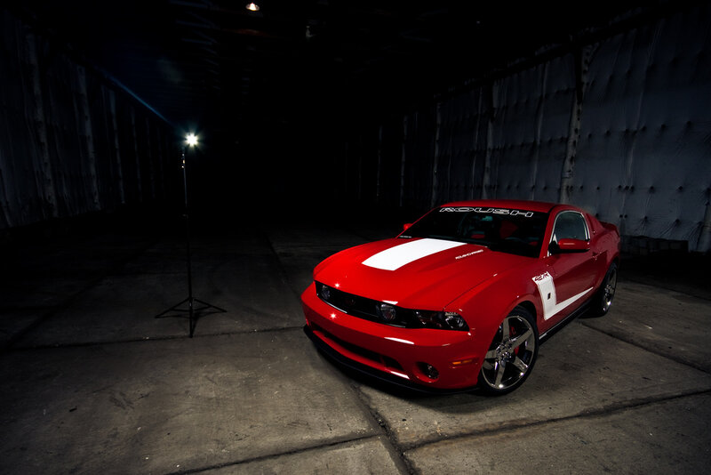 Red Ford Mustang in dark garage