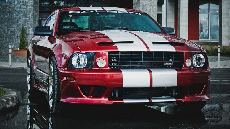 Red Ford Mustang with racing stripes