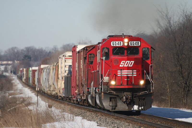 Red freight train on winter tracks