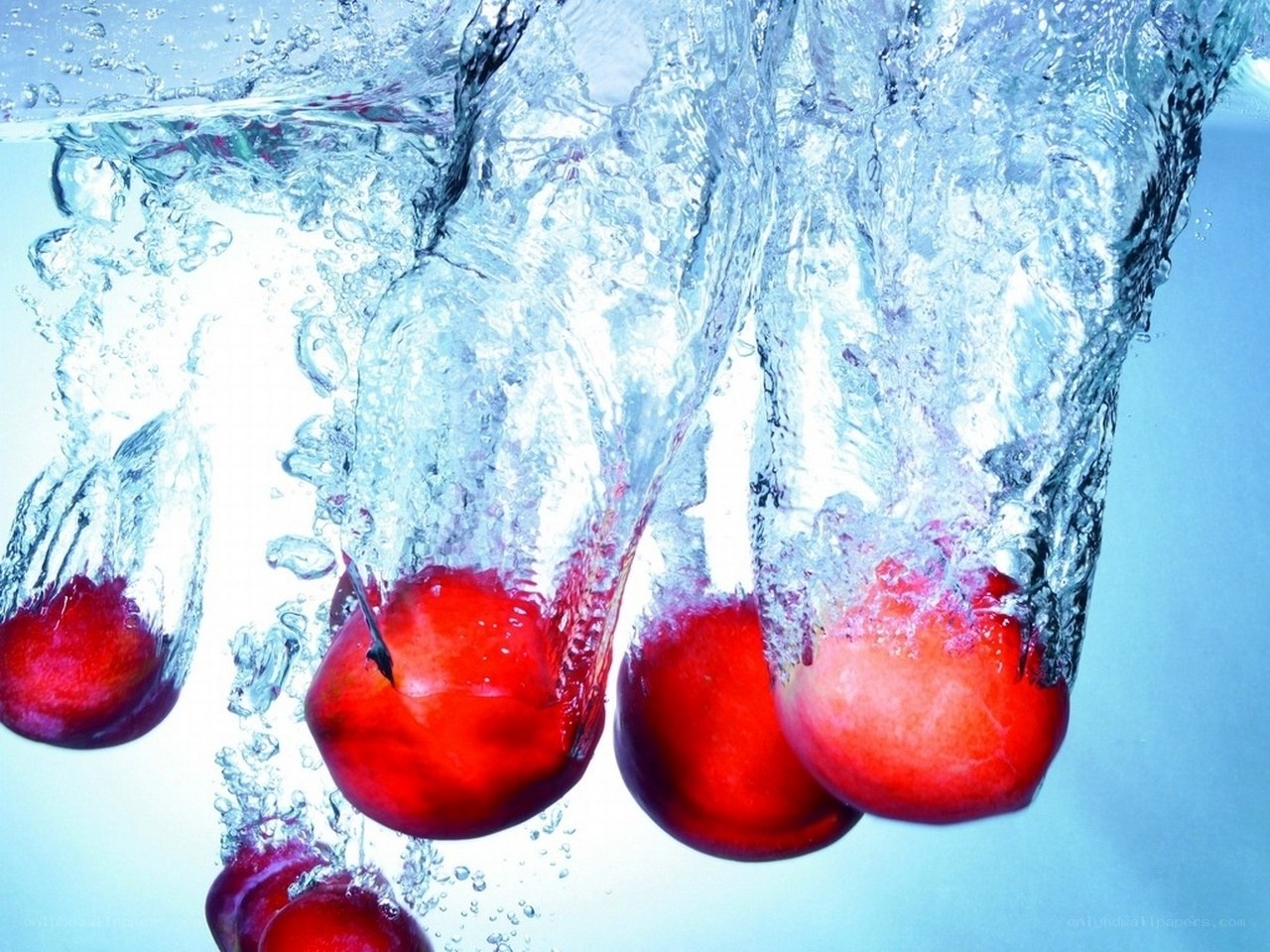 Red fruits falling into water