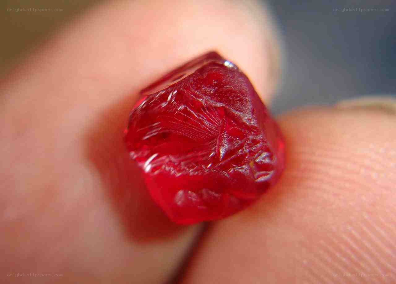 red gemstone on finger
