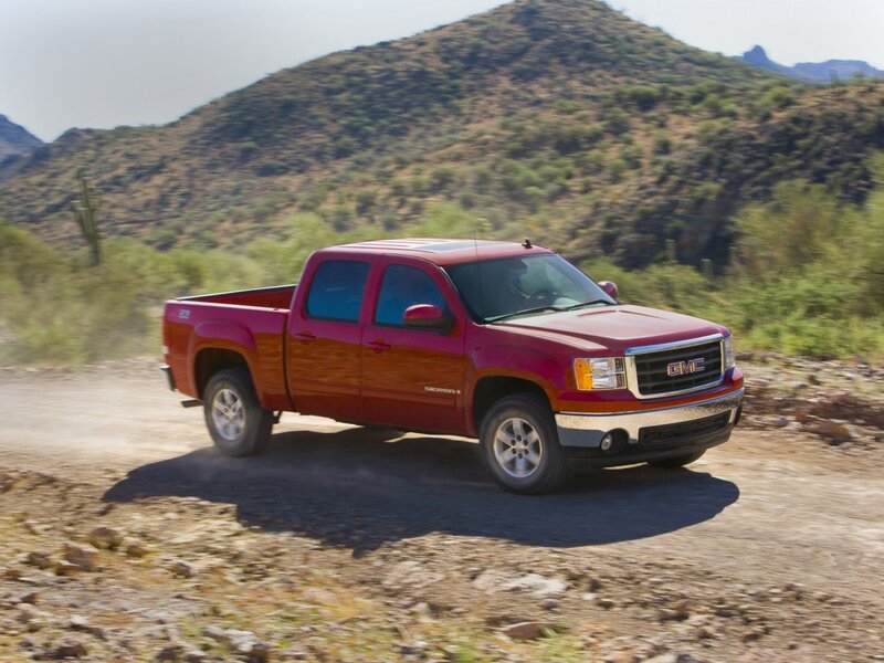 Red GMC Sierra on dirt road