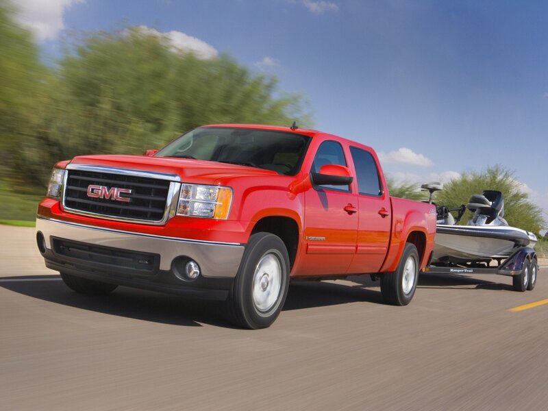 Red GMC Sierra towing boat