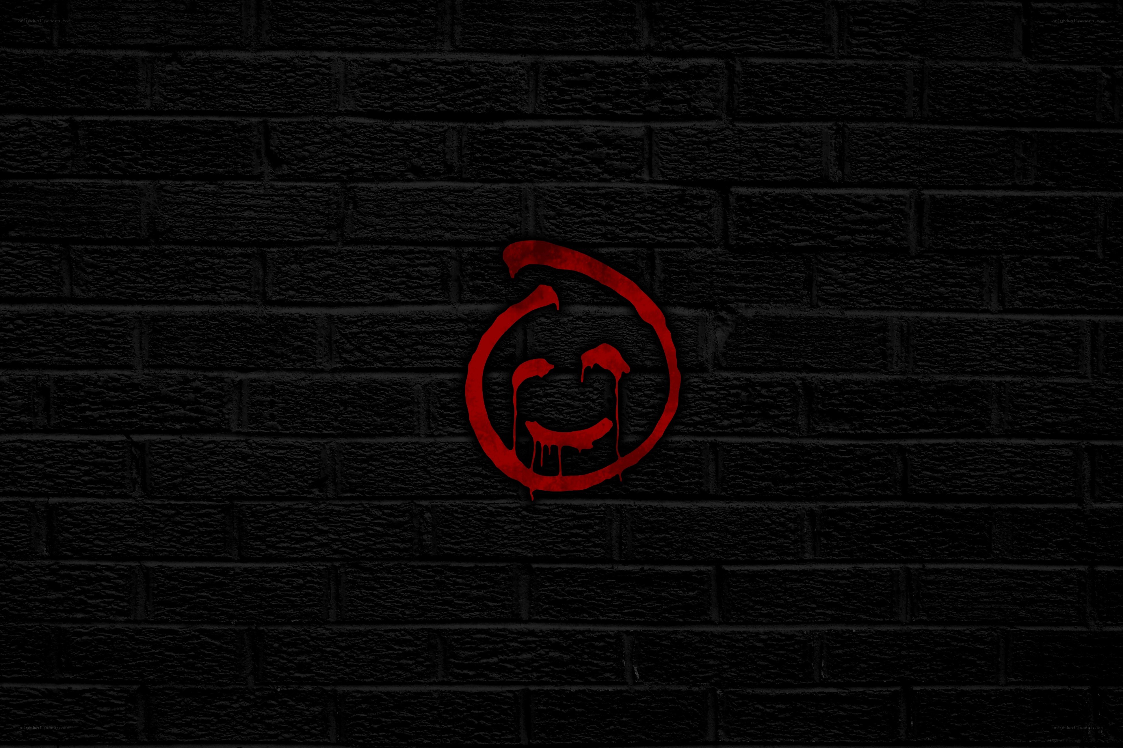 red graffiti smiley on brick wall