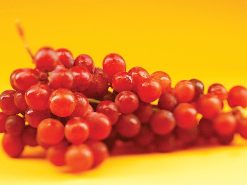 red grapes on yellow background