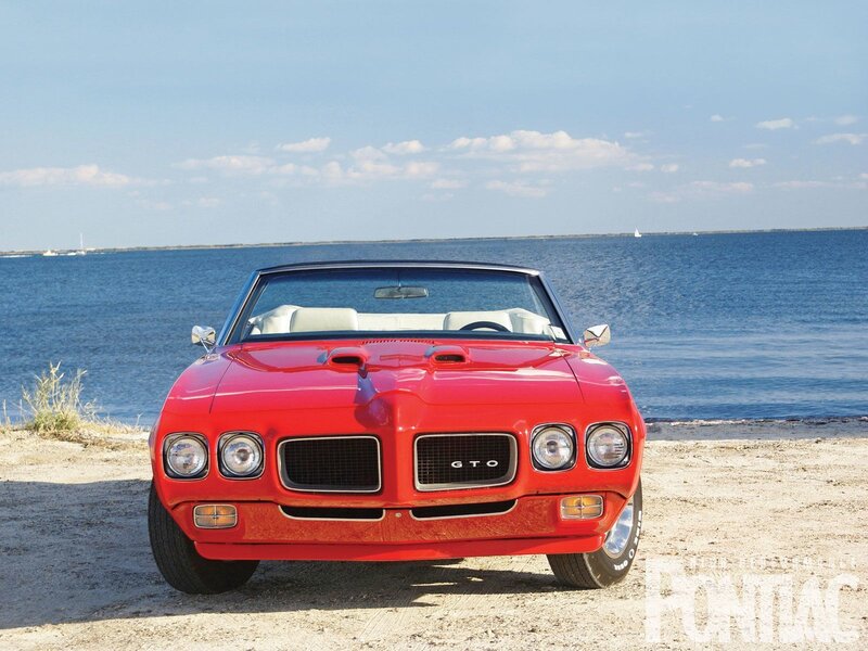 Red GTO convertible by the water