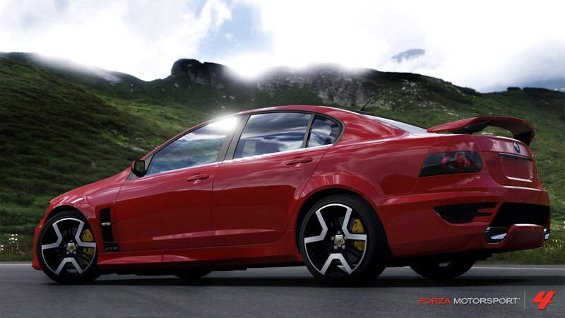 Red GTS sedan on mountain road