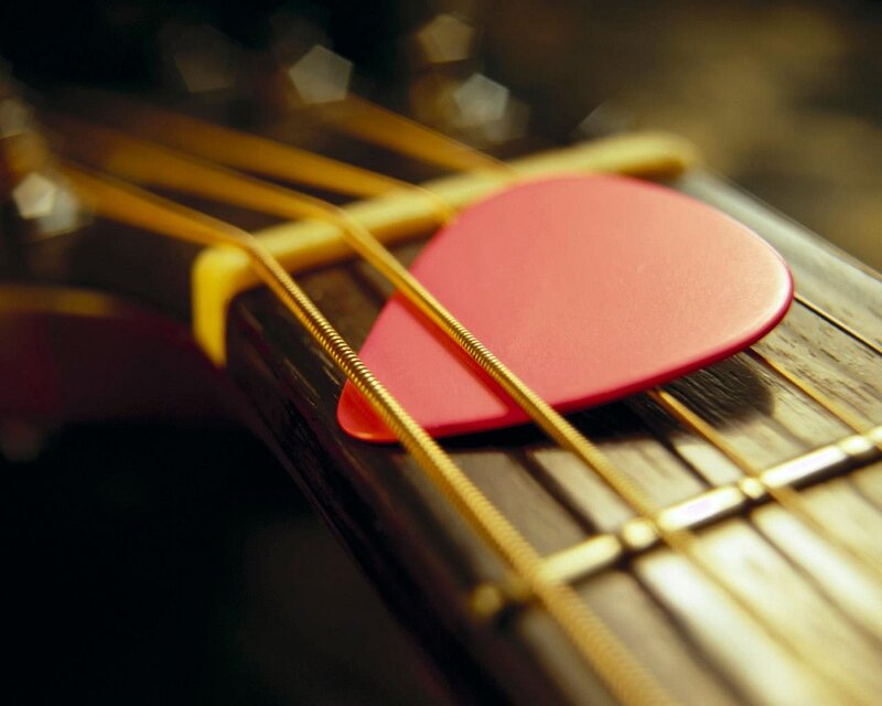 Red Guitar Pick on Strings