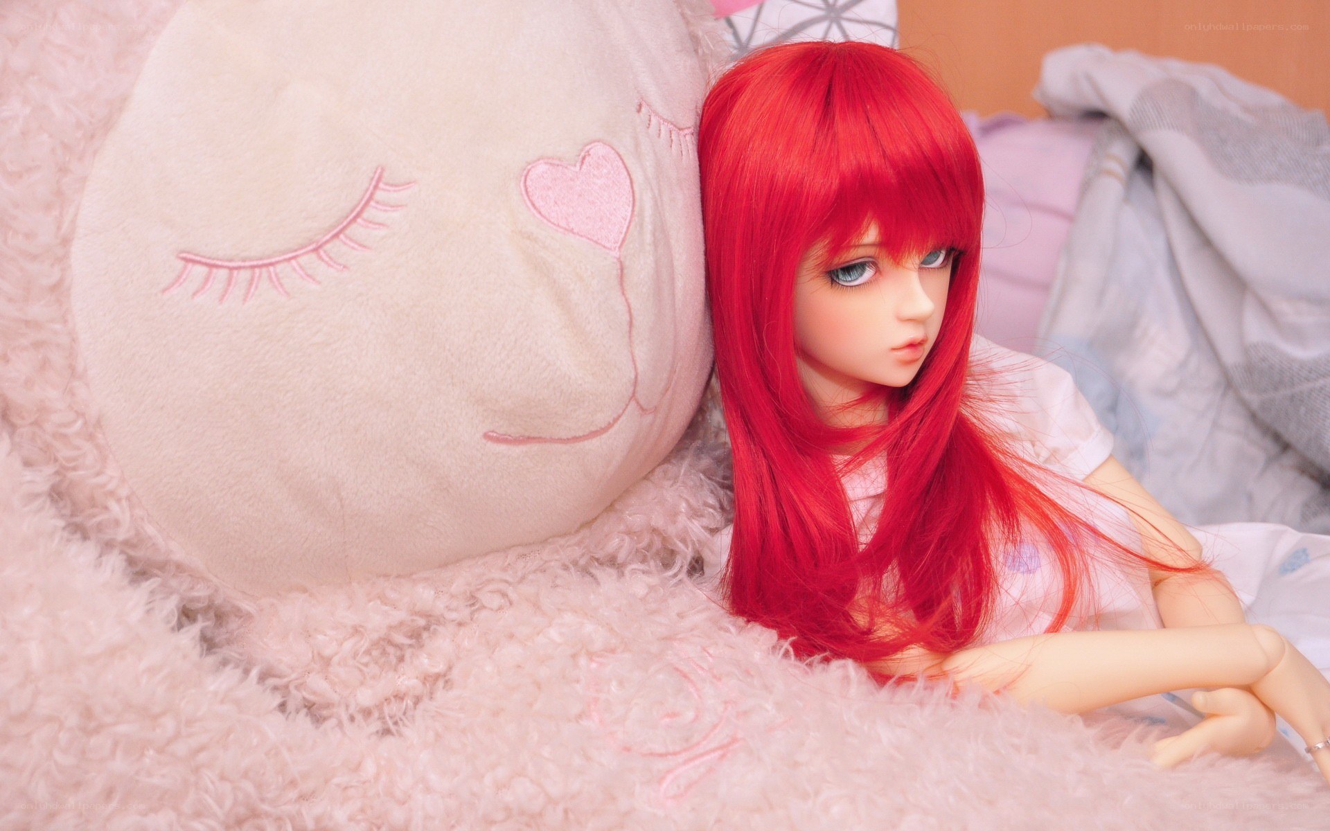 Red-haired doll on a plush pillow