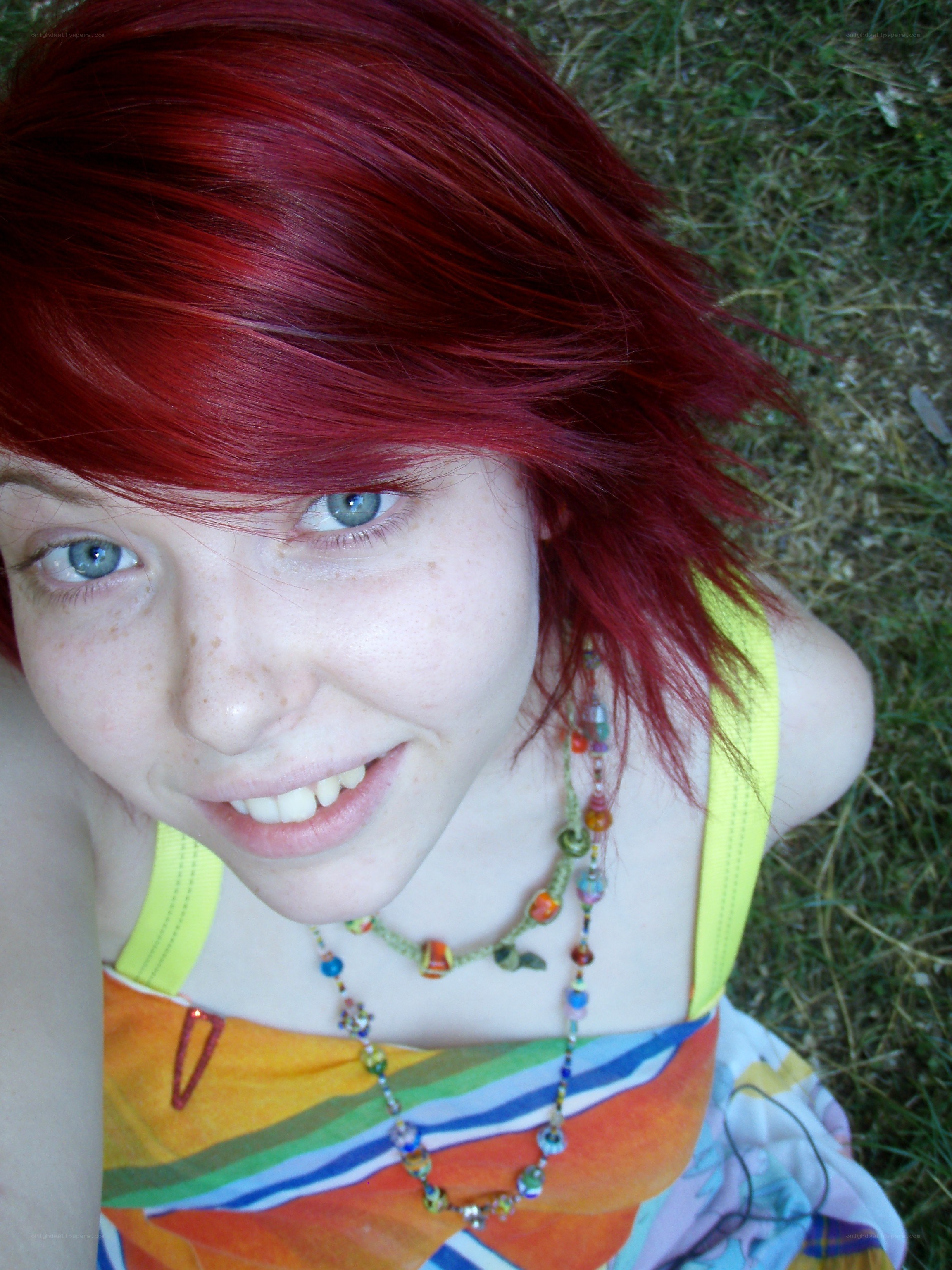 red-haired girl smiling on grass