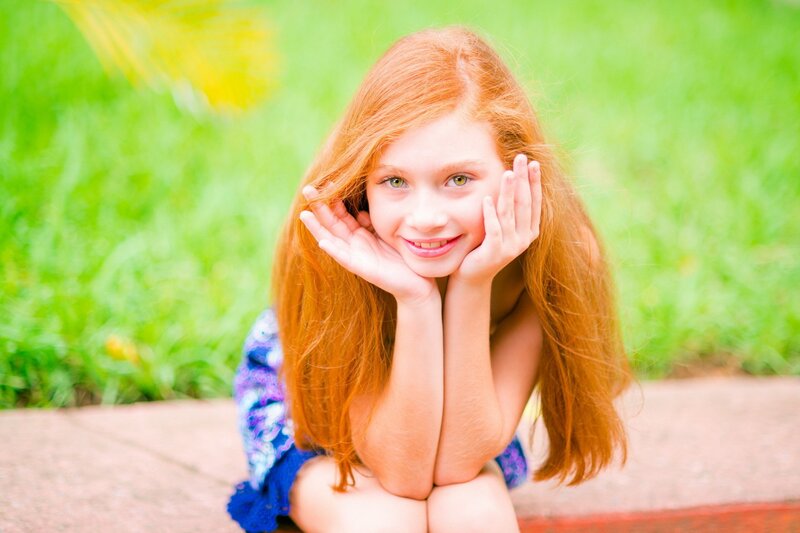 red-haired girl smiling outdoors