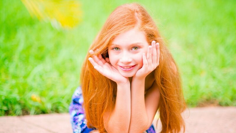 red-haired girl smiling outdoors
