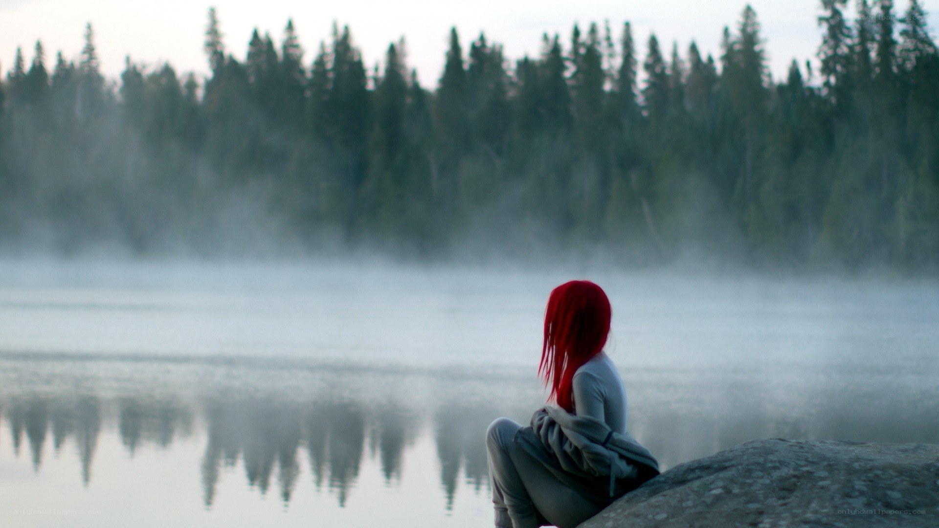 Red-haired person by a misty lake