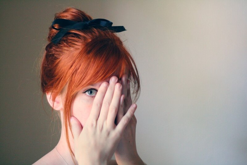 Red-haired Person Covering Face