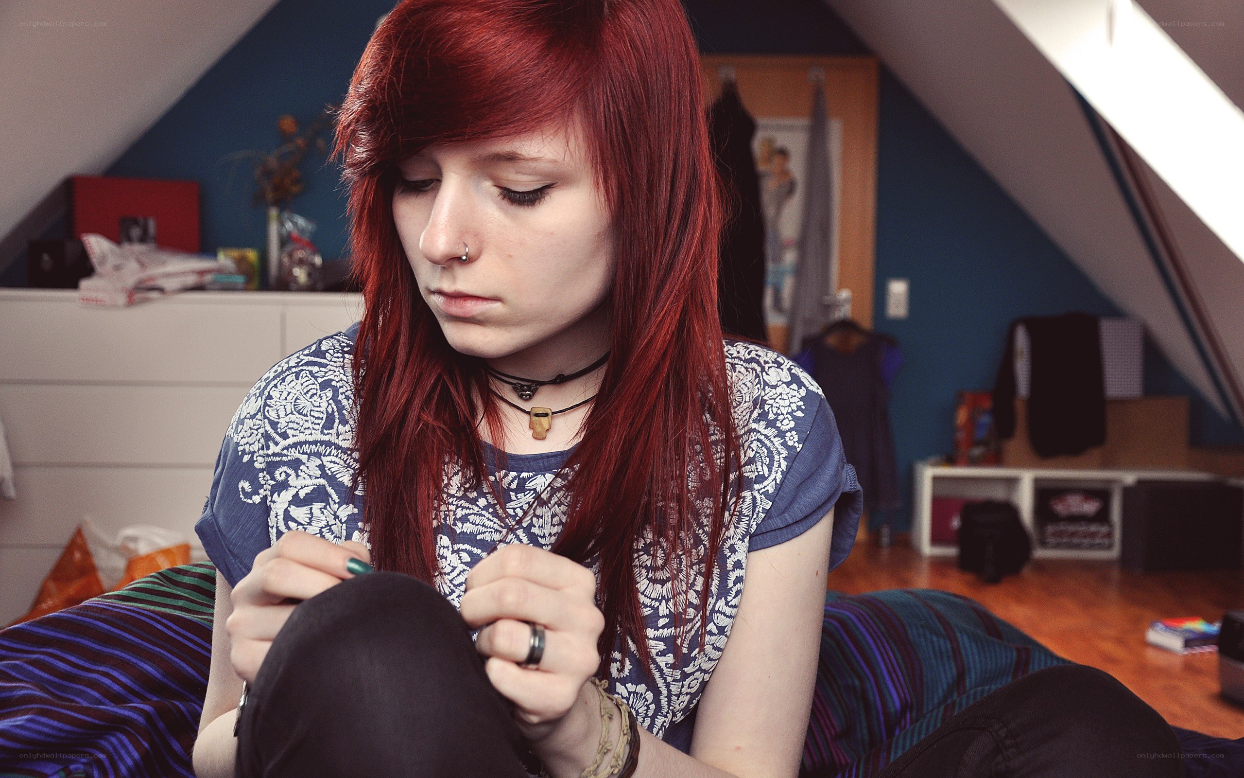 red-haired person sitting on bed
