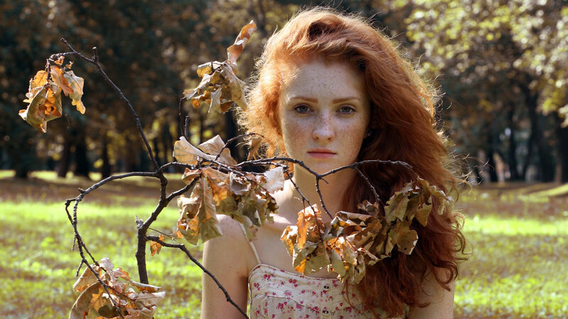 Red-haired woman in autumn park
