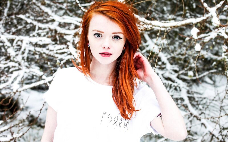 Red-haired woman in snowy forest