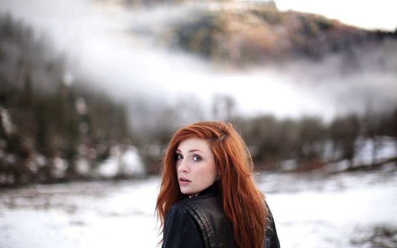 Red-haired woman in snowy landscape