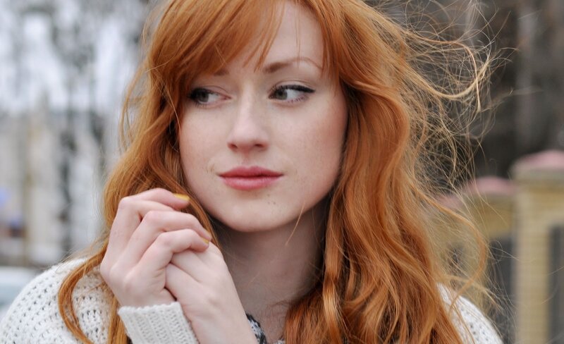 red-haired woman in white sweater
