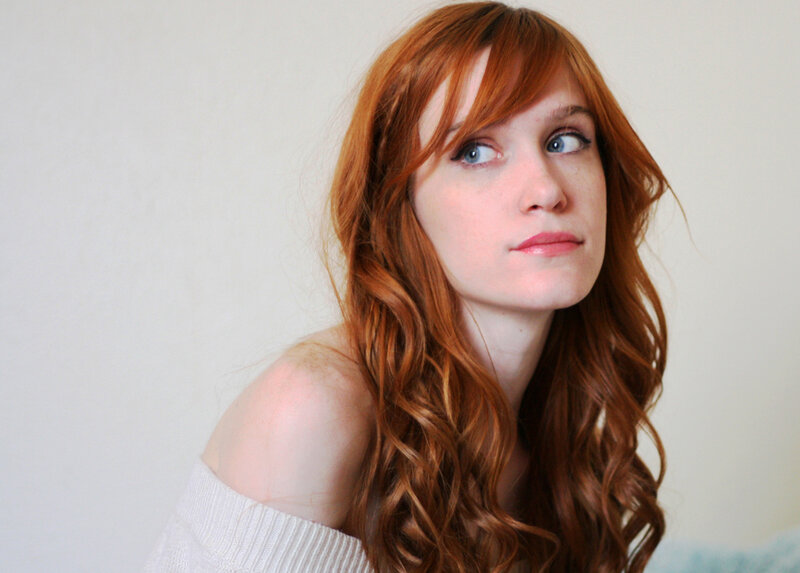 red-haired woman in white sweater