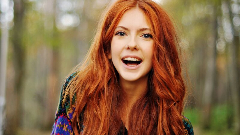 red-haired woman laughing outdoors