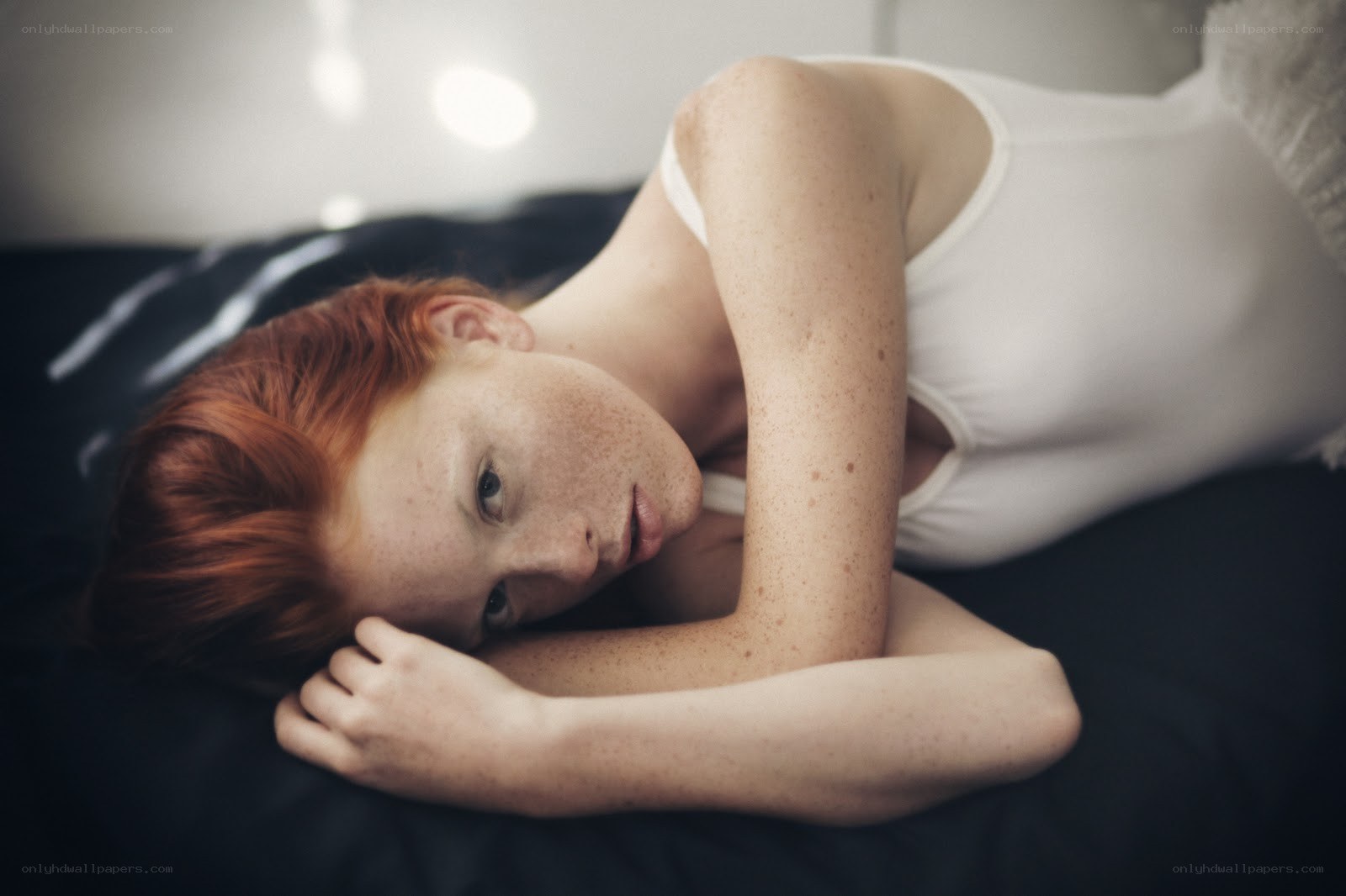 red-haired woman lying on bed