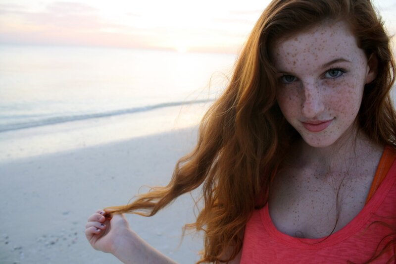 Red-haired woman on beach at sunset