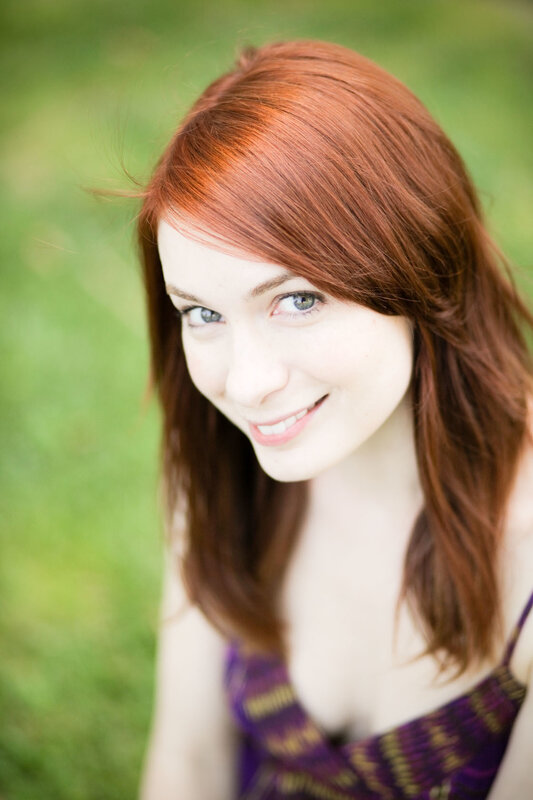 red-haired woman smiling outdoors