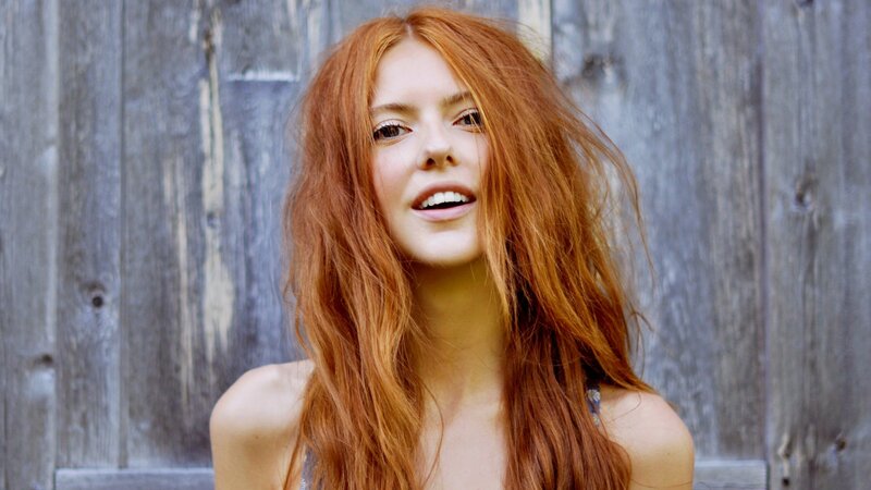 Red-haired woman smiling outdoors