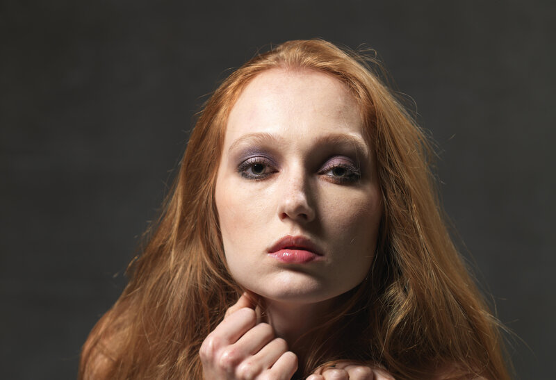 red-haired woman with purple makeup