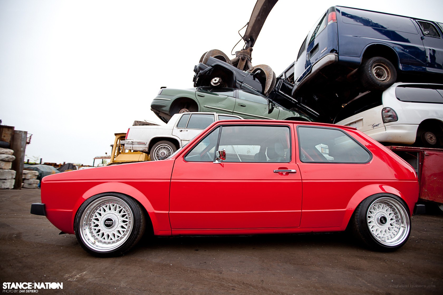 Red hatchback in junkyard