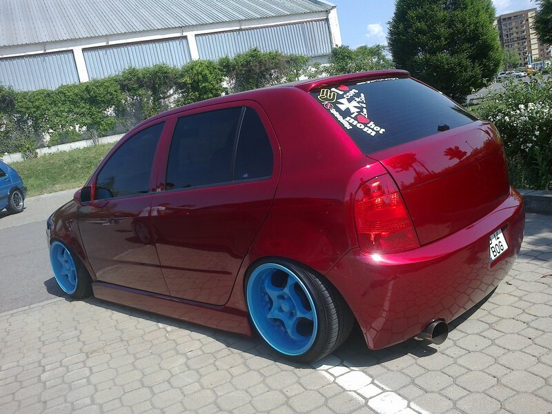 red hatchback with blue wheels