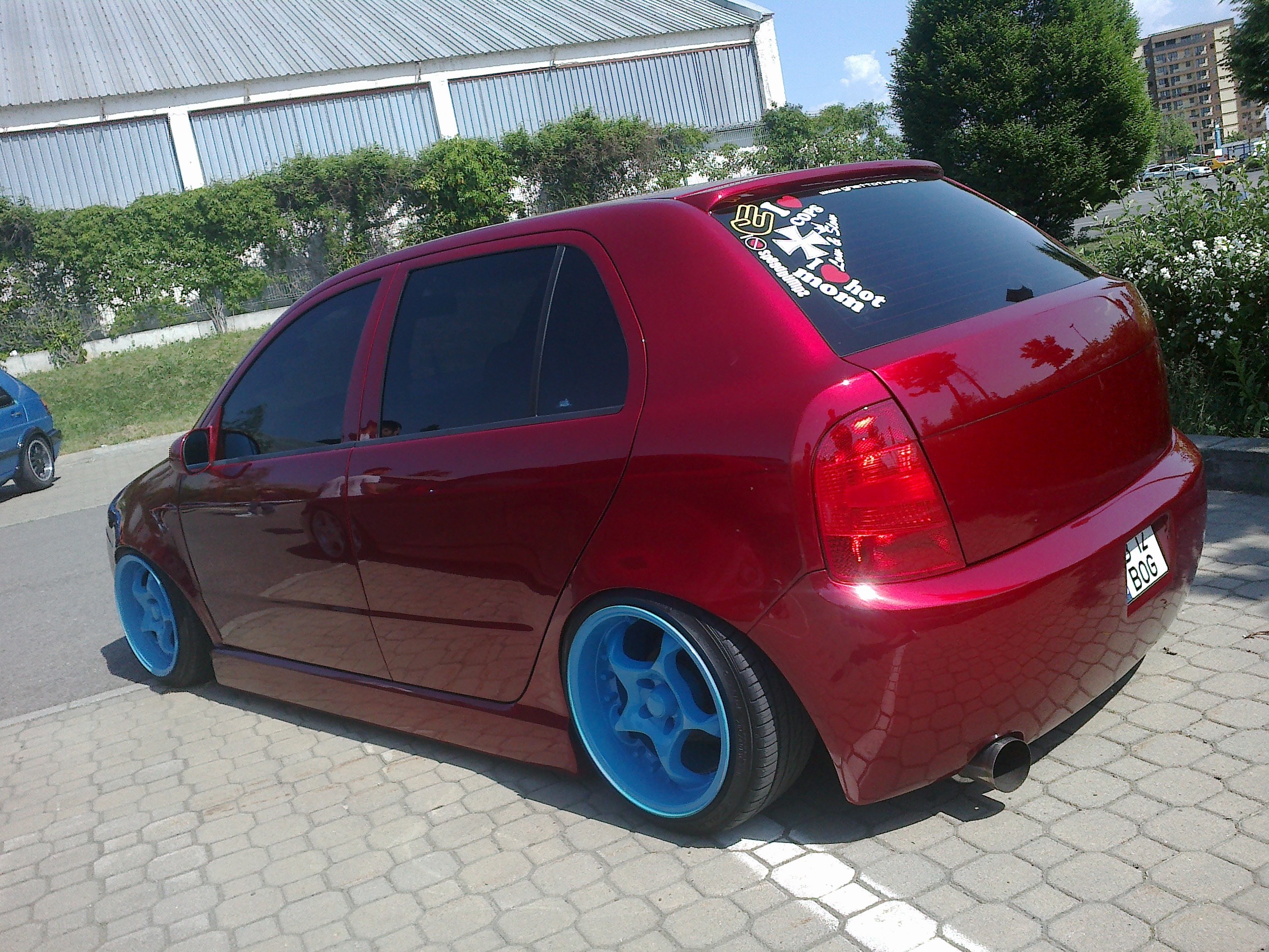 red hatchback with blue wheels