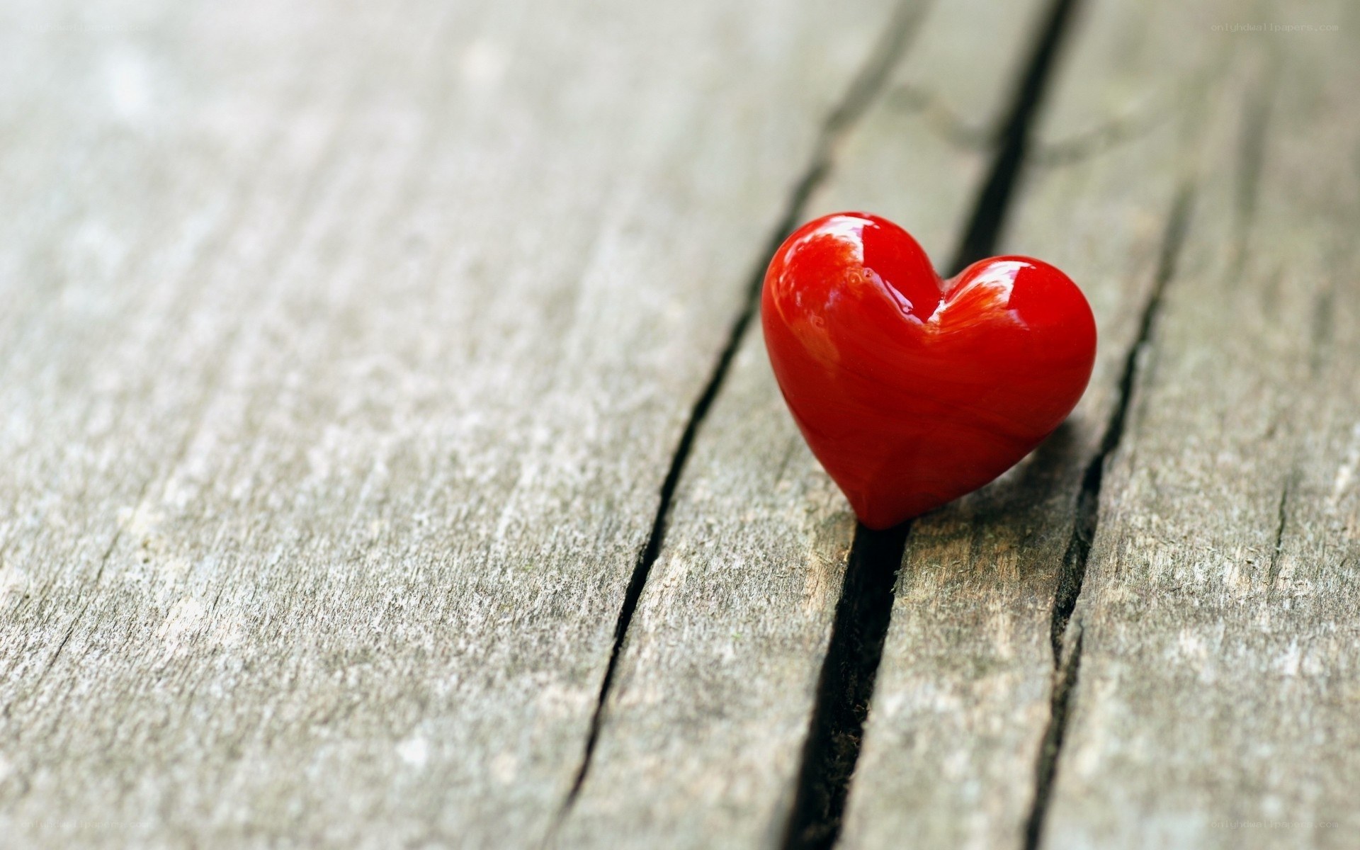 Red heart on wooden surface