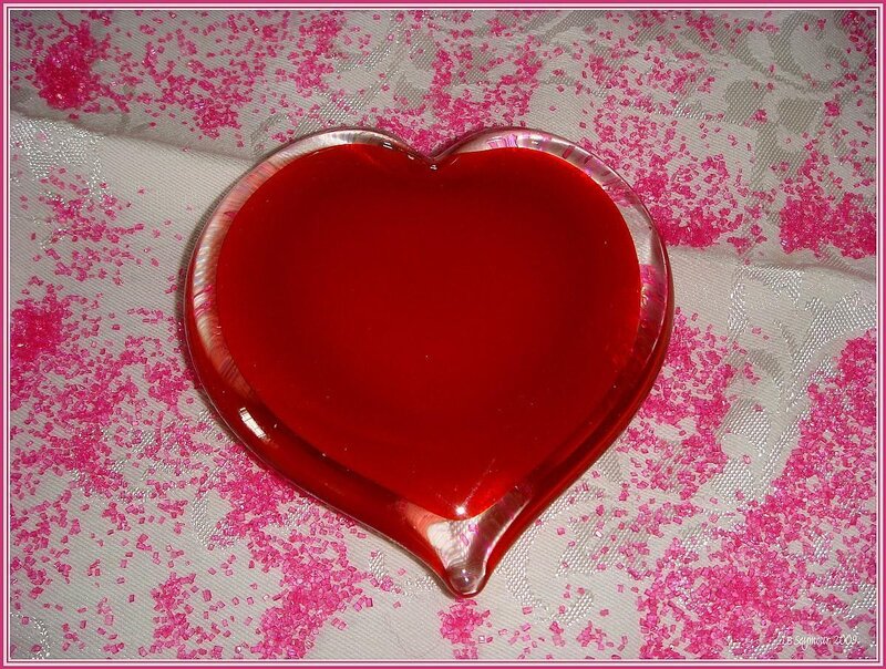 Red heart-shaped jelly on pink sprinkles