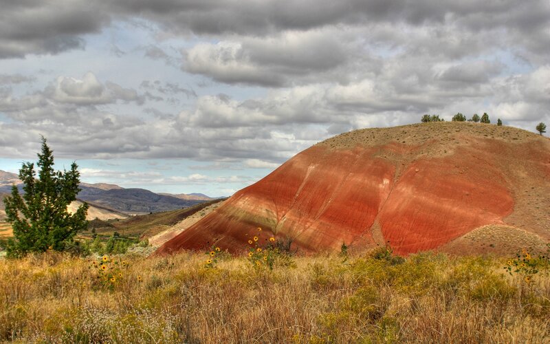 Red hill under cloudy sky