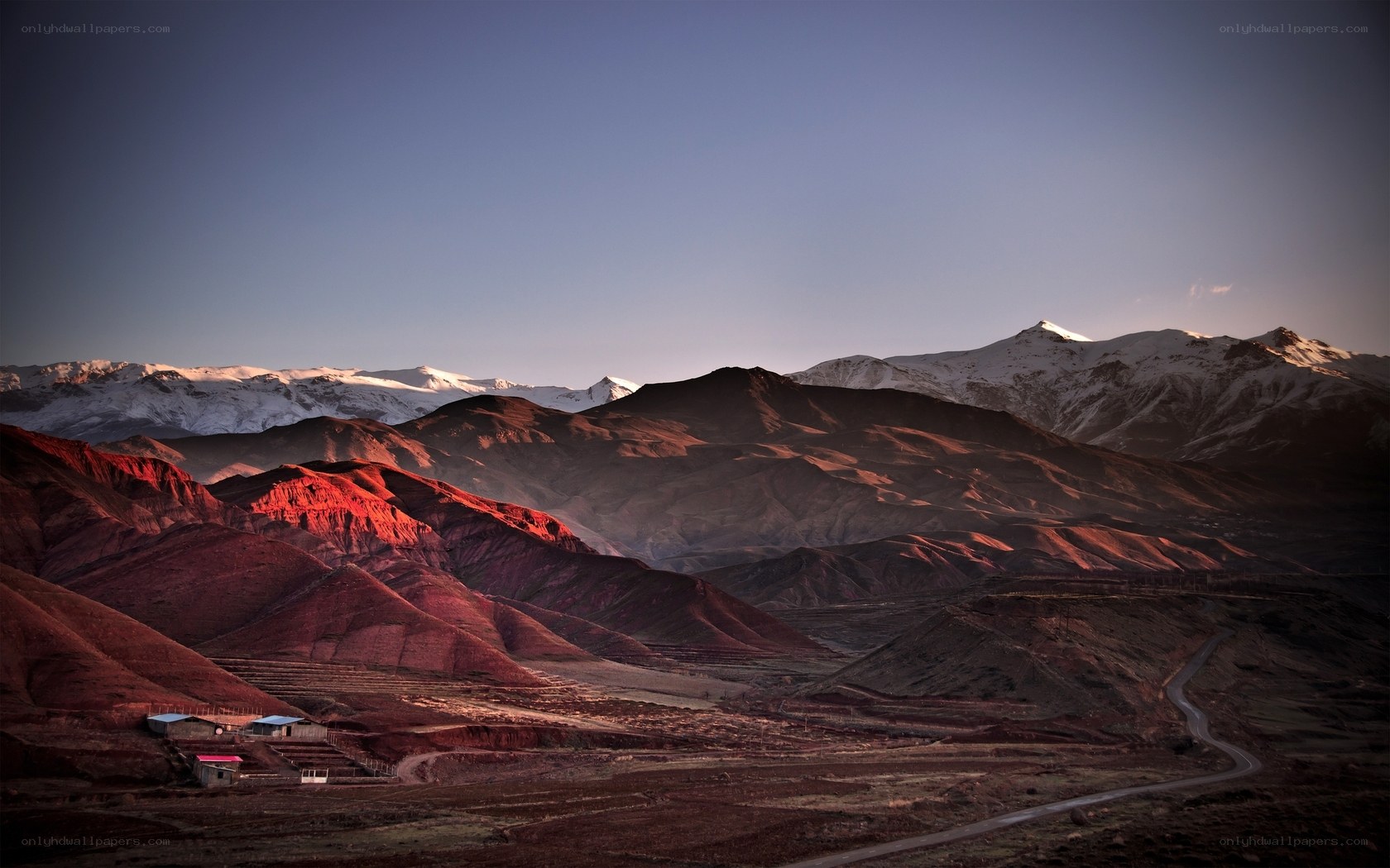 Red Hills and Snow-Capped Mountains
