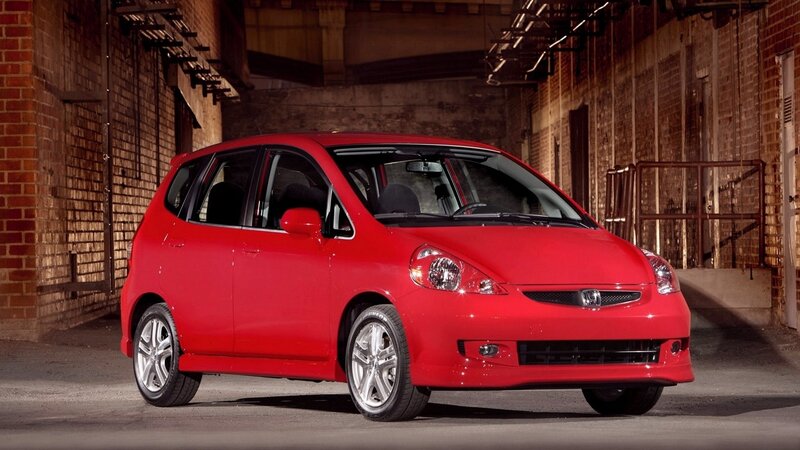 Red Honda Fit in urban setting