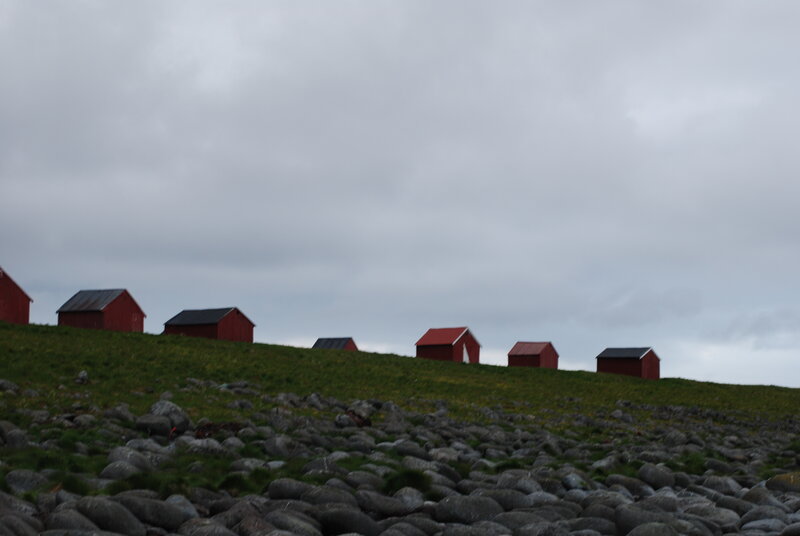 Red huts on a grassy hill