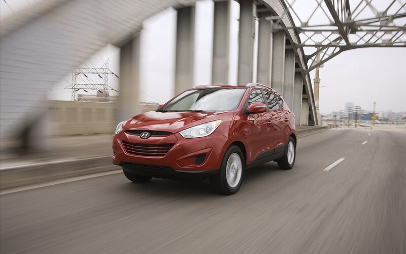 Red Hyundai Tucson driving on a bridge