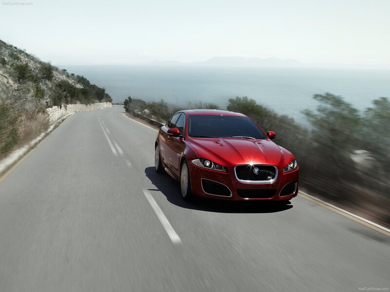 Red Jaguar driving on coastal road