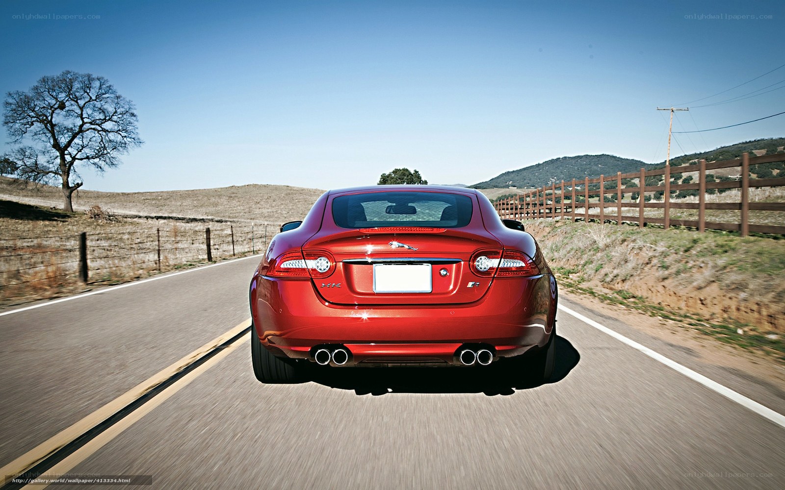 Red Jaguar driving on country road