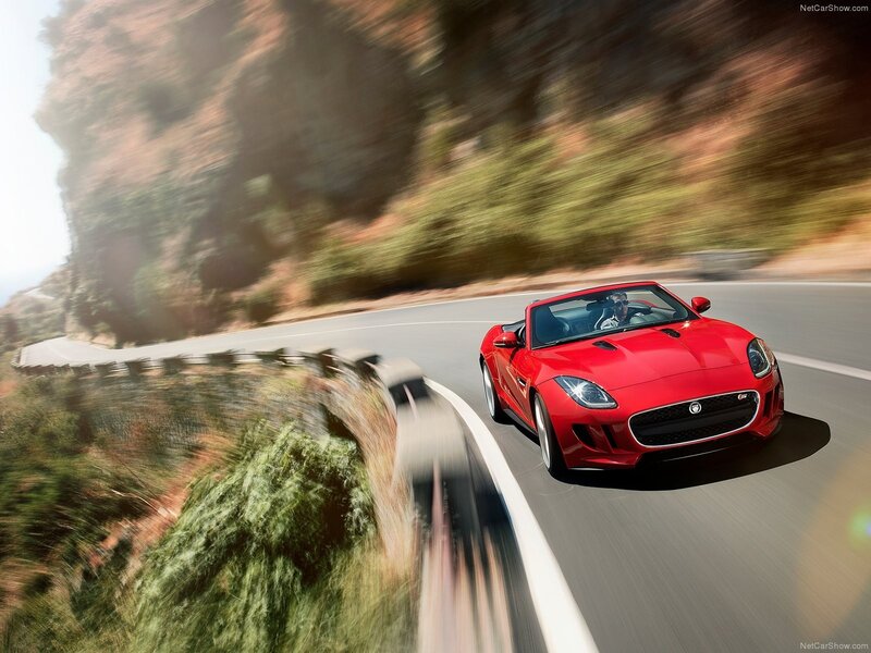 Red Jaguar F-Type driving on a winding road