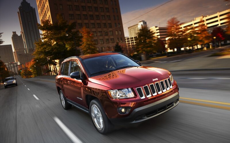 Red Jeep Compass driving in city