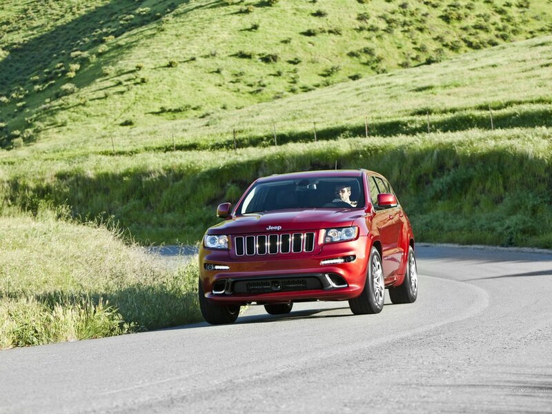 Red Jeep driving on a country road