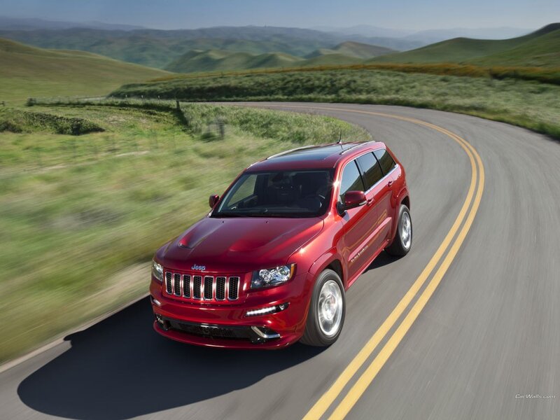 Red Jeep driving on a winding road