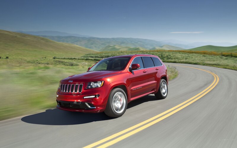red jeep driving on a winding road